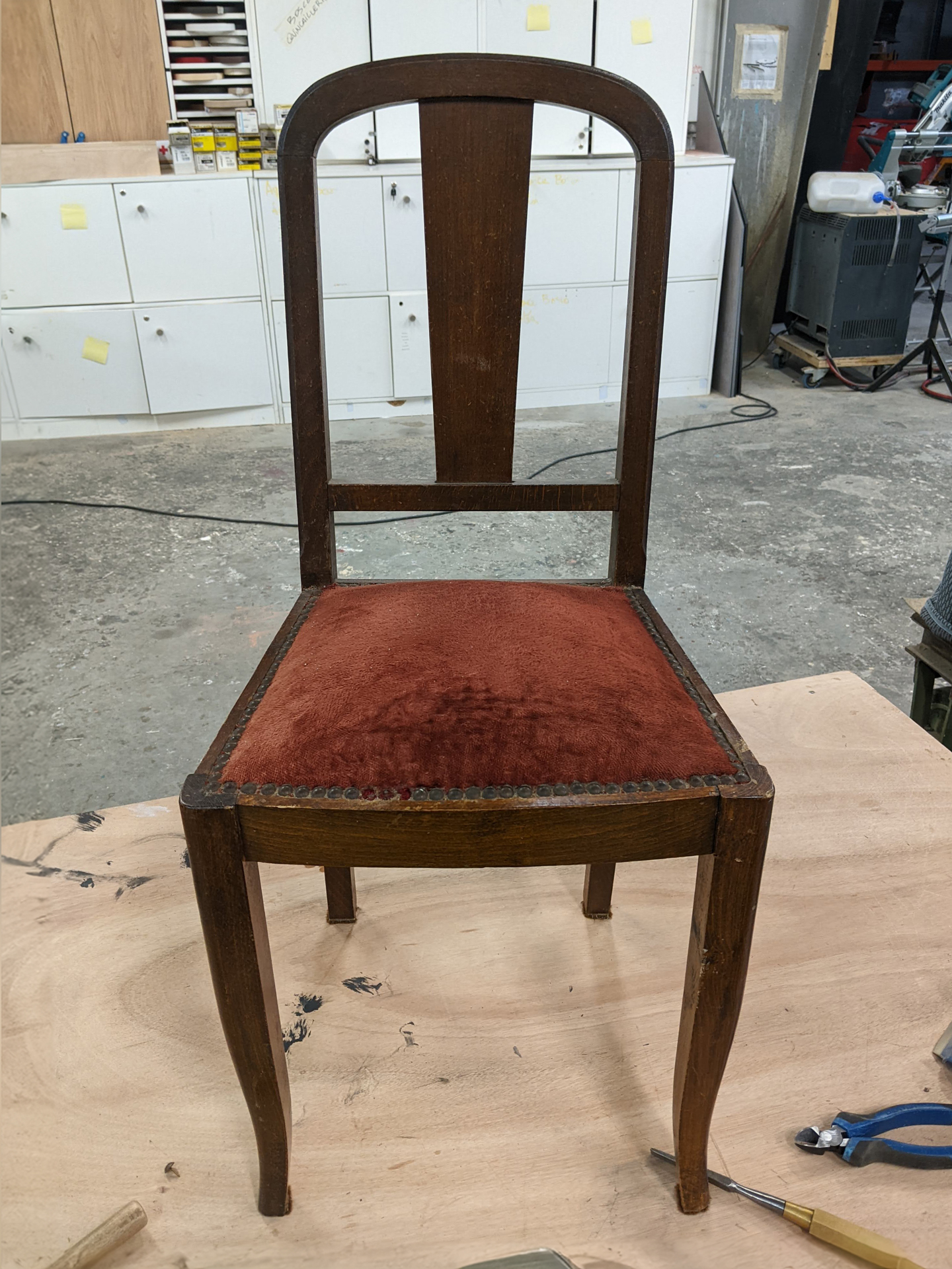 La chaise a un dossier en bois et du tissu en velours orange sur l’assise. Le bois est marron foncé!