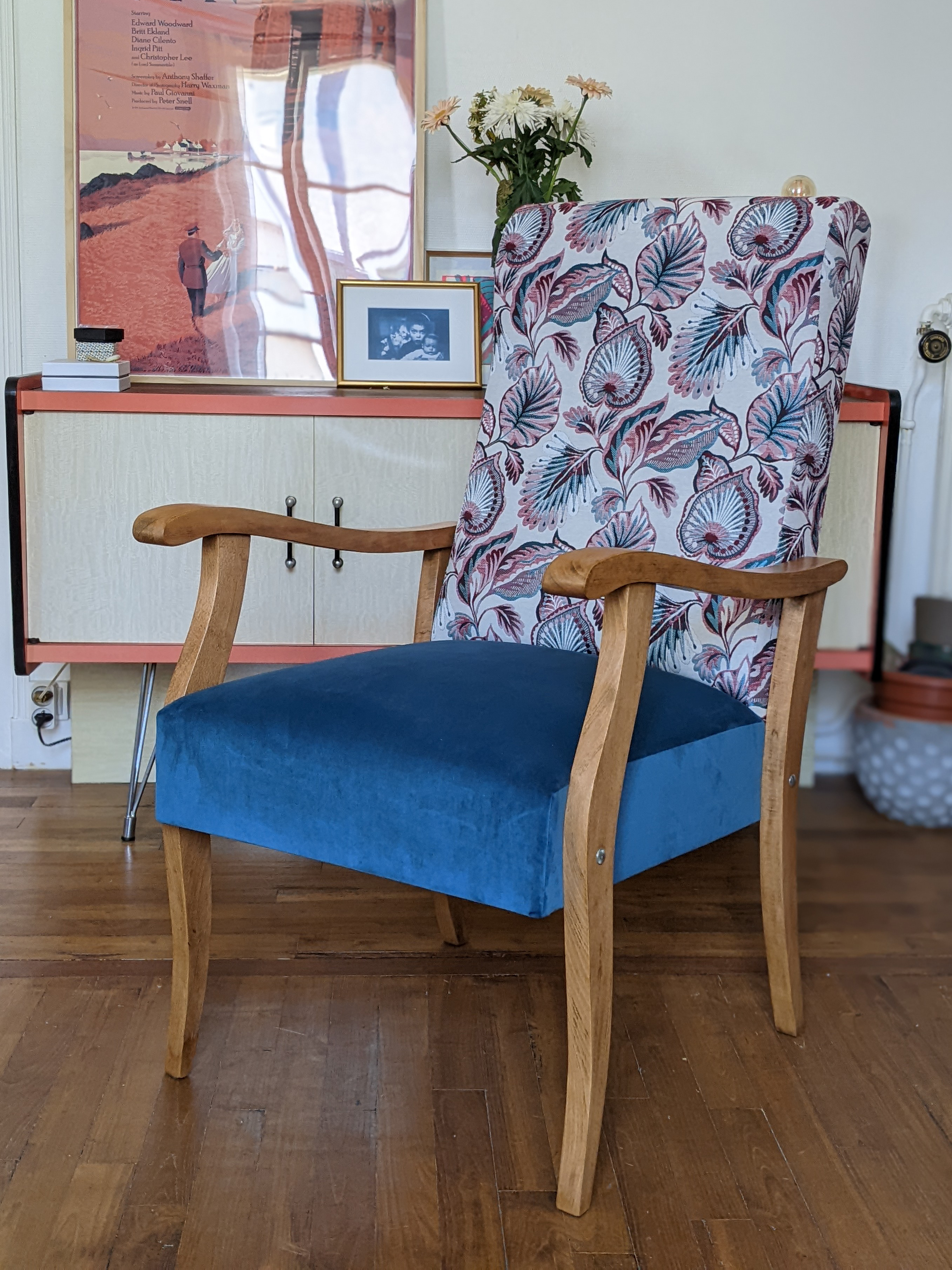 Le fauteuil est installé dans le séjour de l’appartement, sur le parquet en bois massif devant une commode en formica!