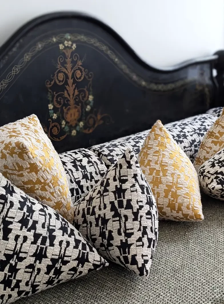 Canapé recouvert de coussins de différentes formes, berlingot et traversins