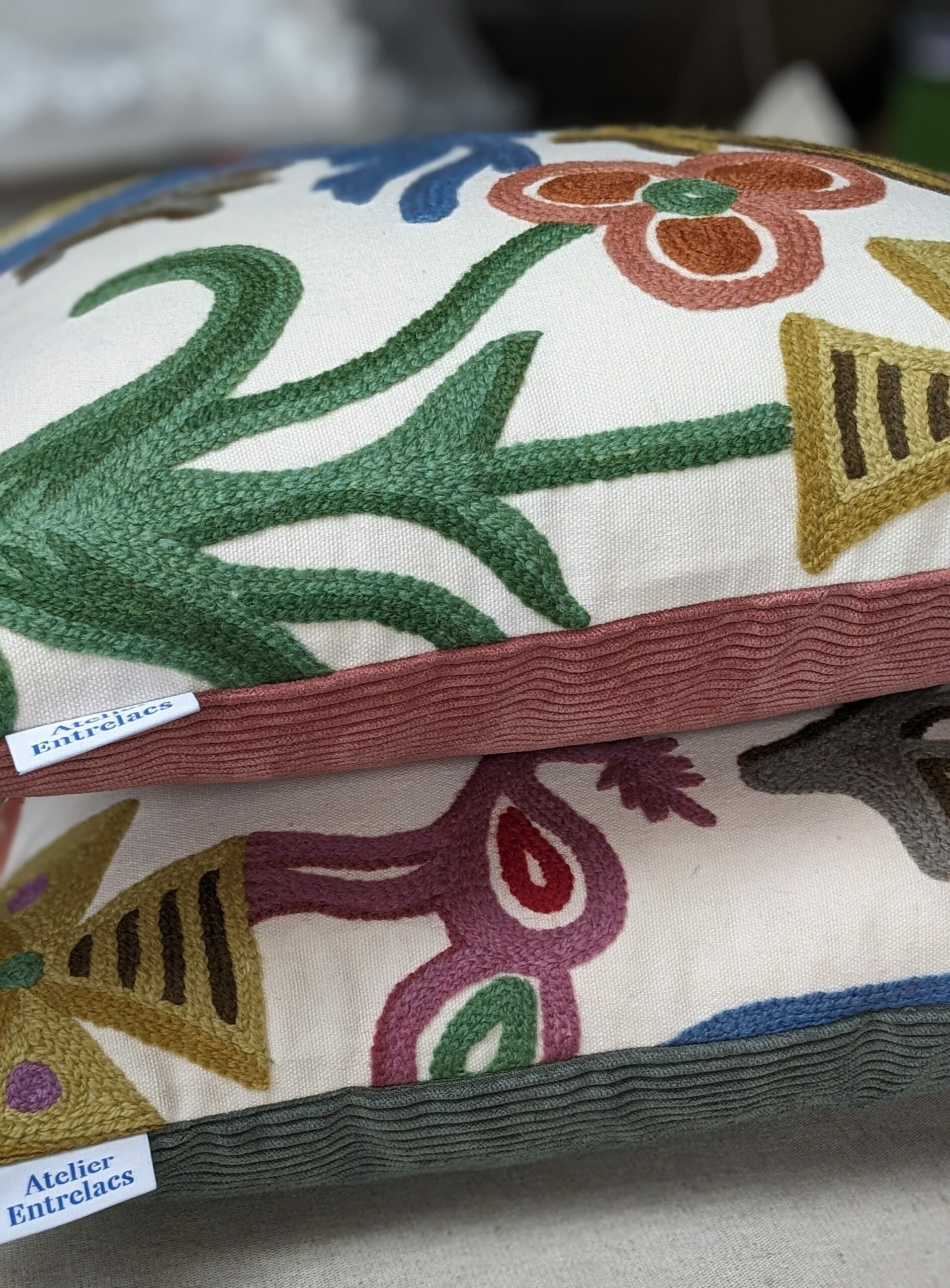 Deux coussins décoratifs empilés fabriqués dans un tissu brodé et un velours côtelé