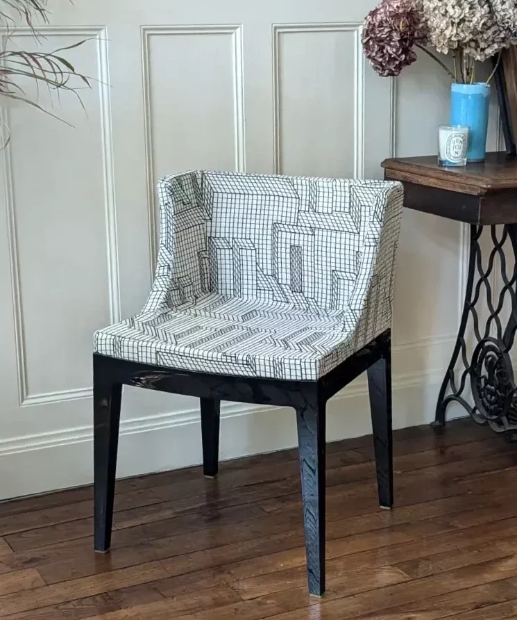 Fauteuil modèle Mademoiselle designé par Philippe Starck recouvert d'un tissu géométrique de la marque Elitis